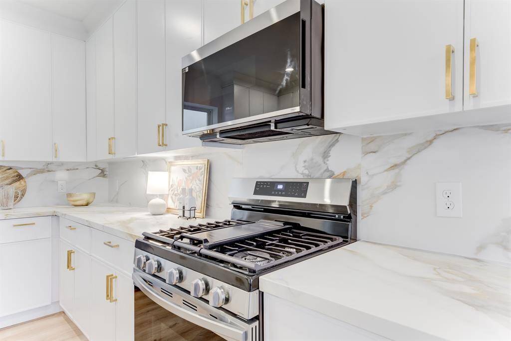 6 burner gas range with modern  microwave and quartz countertops.