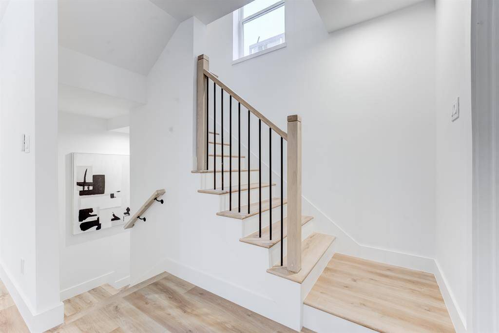The stunning staircase and  banister matches the luxury vinyl  plank flooring throughout the  home leads to the bedrooms upstairs.