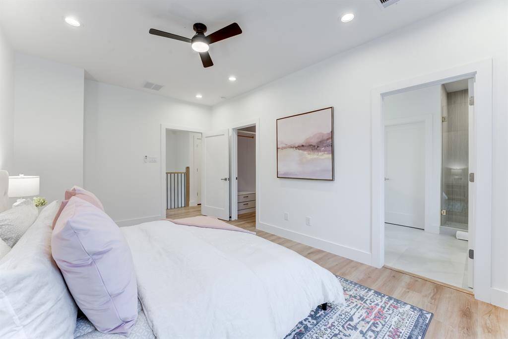 This spacious primary suite  features 2 large windows for  natural light, recessed lighting,  and a ceiling fan.