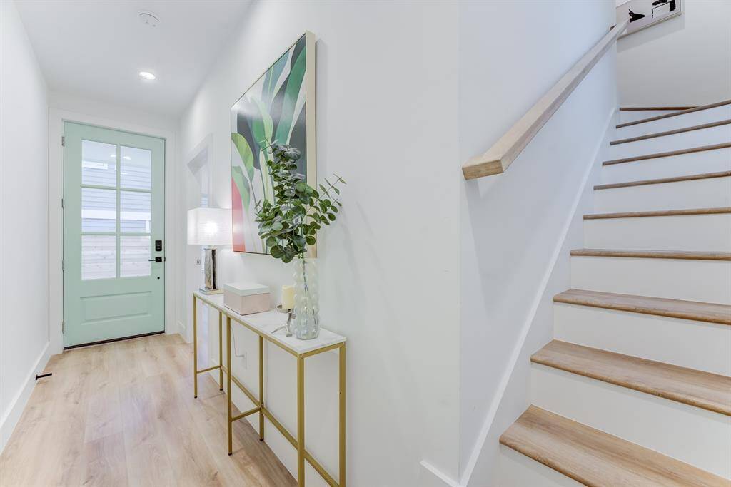 The stunning staircase and banister matches the luxury vinyl plank flooring throughout the  home.