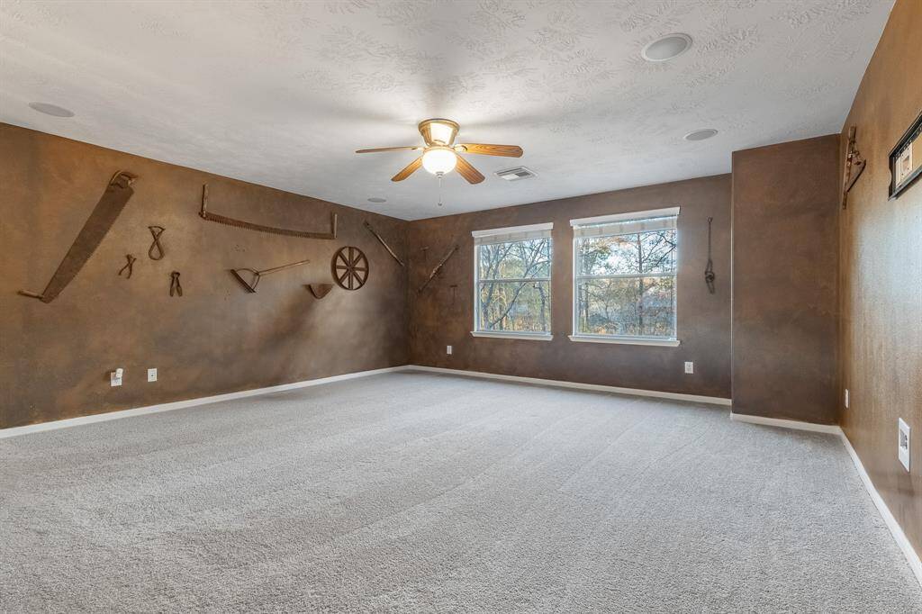 Upstairs has a game room or second living space that overlooks the backyard