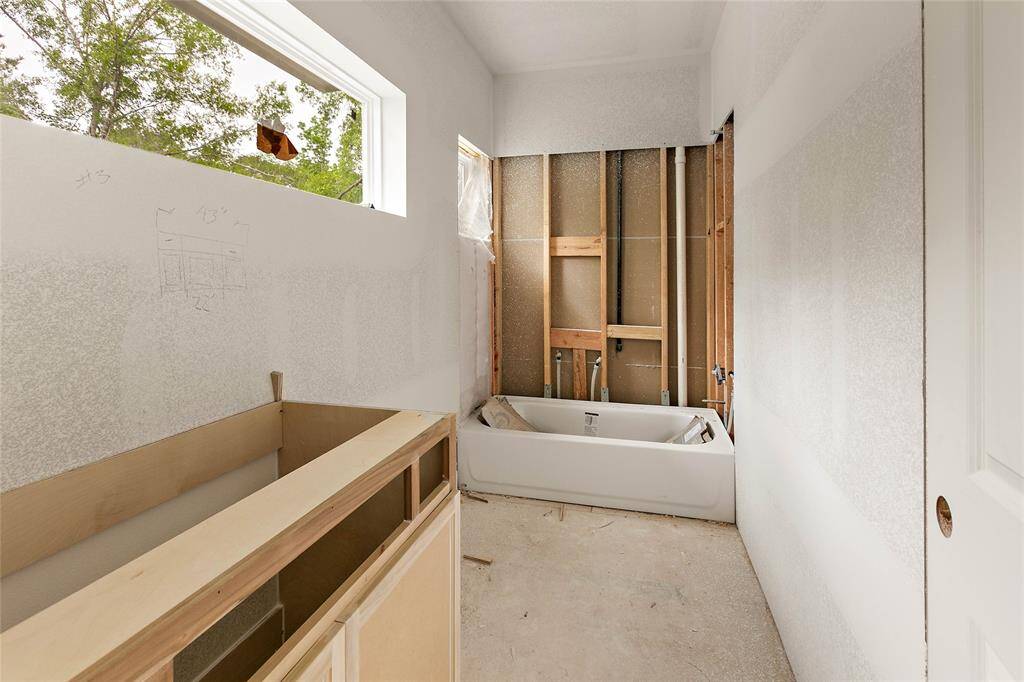 Natural light illuminates a full bath located upstairs, offering views of towering trees.