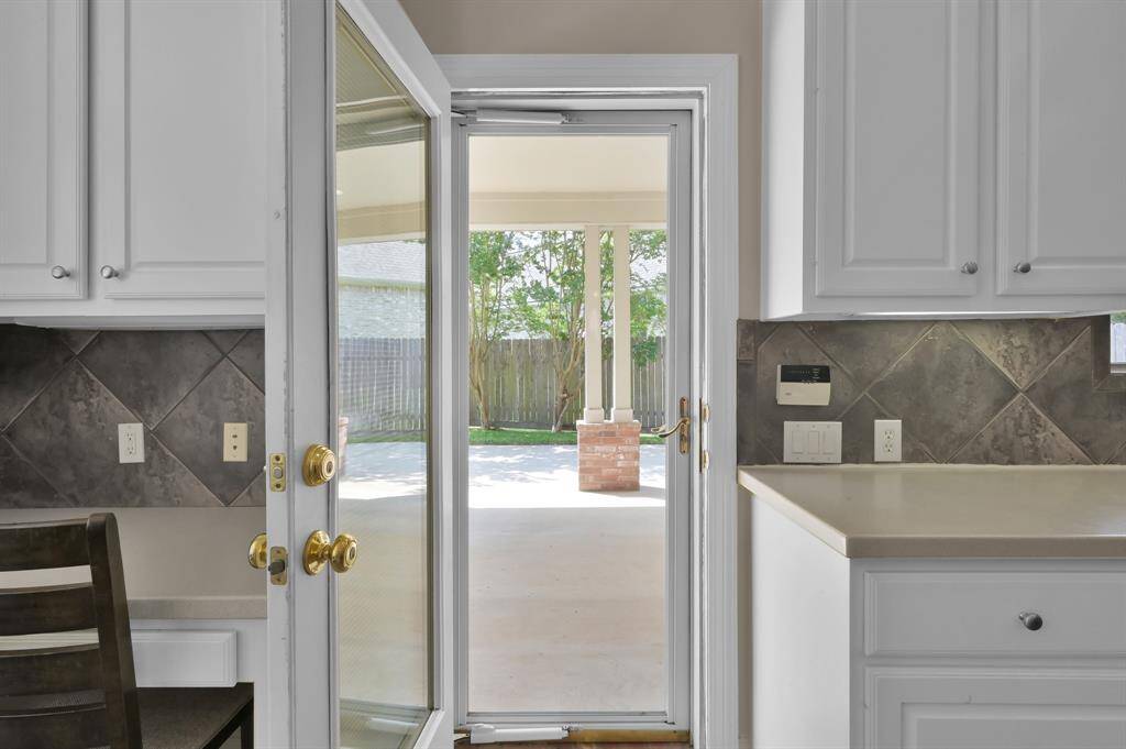 A side entrance door with a built-in blind in the kitchen leads to the driveway and porte-cochere. There is also a lockable glass storm door here as well.