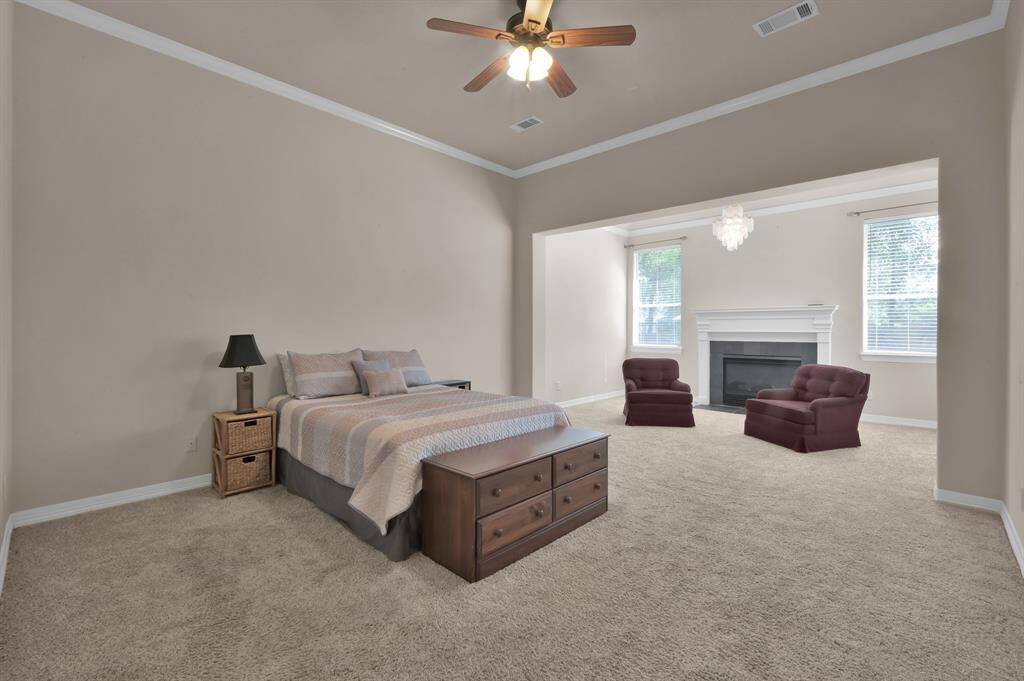 With a private entry, the primary bedroom suite offers plenty of room for a king-size bed and multiple furniture pieces. It has 10' ceilings, crown molding, neutral paint and a ceiling fan with light. Imagine waking up with views of your back yard.