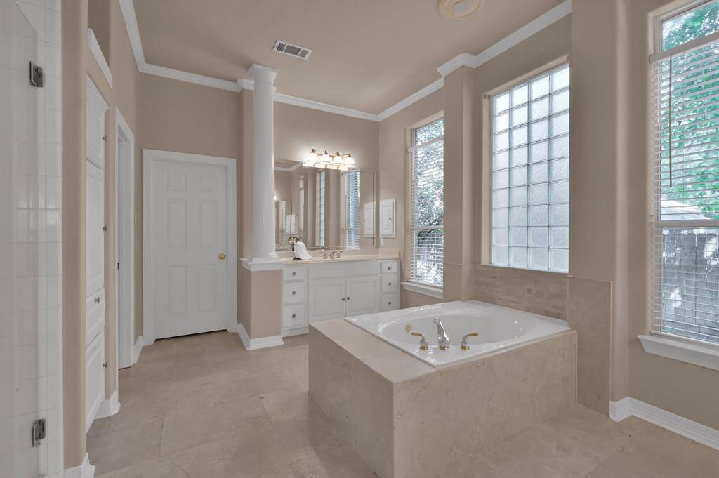 Soak away the troubles of the day in the comfortable tub. Two large windows with faux wood blinds provide needed privacy while the glass block window still allows natural light into the space. A spacious walk-in closet offers space for all your clothing storage needs. There is even a transom window to allow light in the closet without compromising privacy. And water heaters installed in November 2021 and Fall of 2021 will make sure you have lots of hot water.