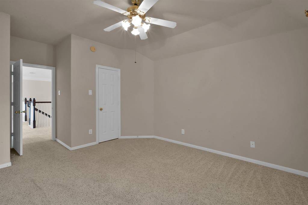 This secondary bedroom is just off the game room at the top of the stairs. It has a gabled ceiling, walk-in closet, ceiling fan with light and looks over a side of the home.