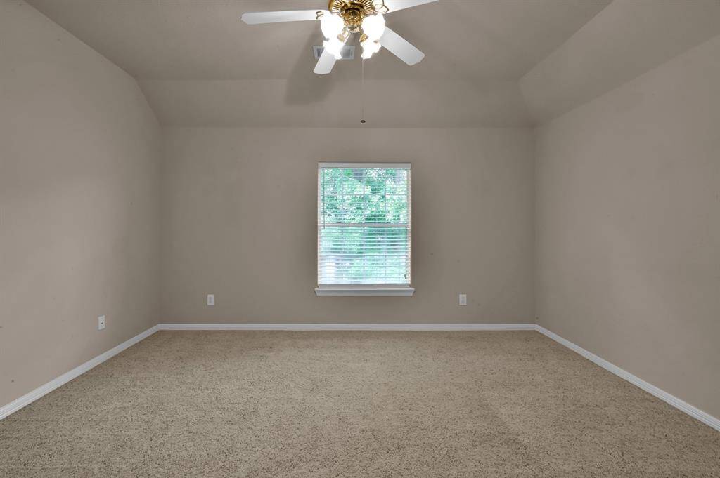 Another secondary bedroom on this side of the home overlooks the front yard. It also has a gabled ceiling, walk-in closet and ceiling fan with light.