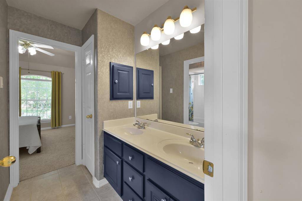 This secondary full bath has dual sinks and inset wood medicine cabinet with a storage/linen closet. There is also a separate room with a tub/shower combo and toilet making it easy for more than one person to use this bathroom at the same time.