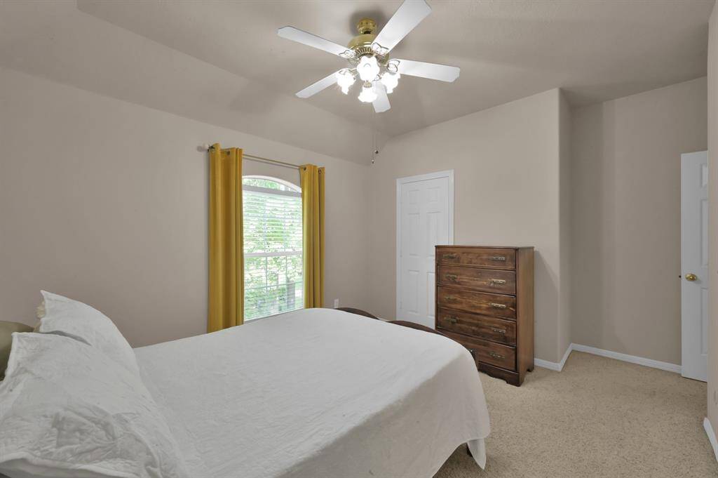 On the other side of the Hollywood bath is the fourth secondary bedroom. It overlooks the front yard, has a gabled ceiling and a walk-in closet with ceiling fan and light.