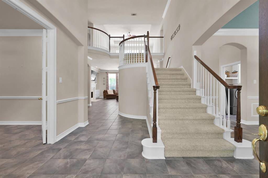 As you enter the grand two-story foyer with hints of the back yard, you will find the study to the left and the dining/flex room to the right. A split staircase allows entrance from the front of the home or the back near the kitchen and living room leading to a Juliet balcony. Just past the study entrance is a reading/art niche with shelves for decor items or books and room for a reading chair or maybe your holiday tree. Across from this you will find a large under stair closet for additional storage.