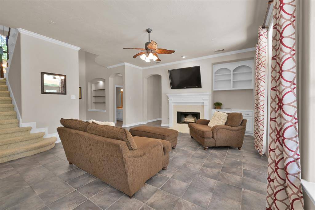 Stay warm on cool Texas evenings using the wood burning fireplace with gas starter. Framed with a white wood mantle and Travertine tile, it's also beautiful to look at on warmer days while the ceiling fan with light are keeping you cool. The built-in shelving and cabinets provide space to display decor items and hide away your A/V equipment and other items.