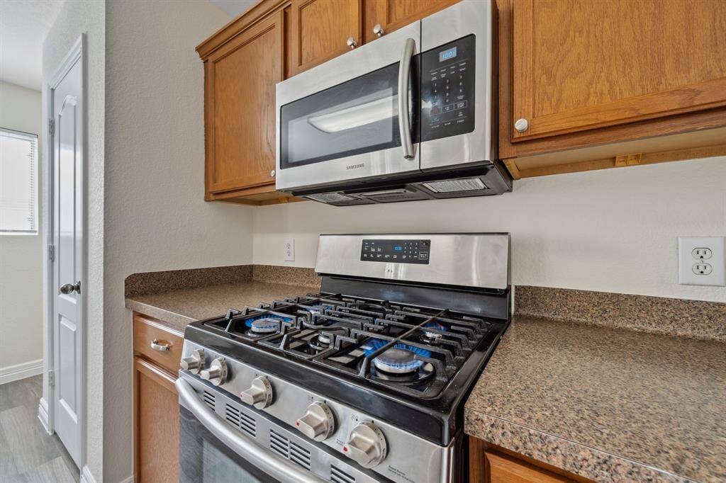 Kitchen features gas range and built-in microwave.
