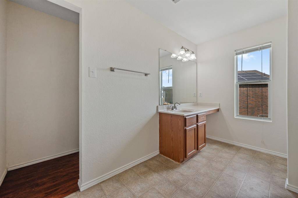 Alternate view of the primary bathroom with vanity and mirror.
