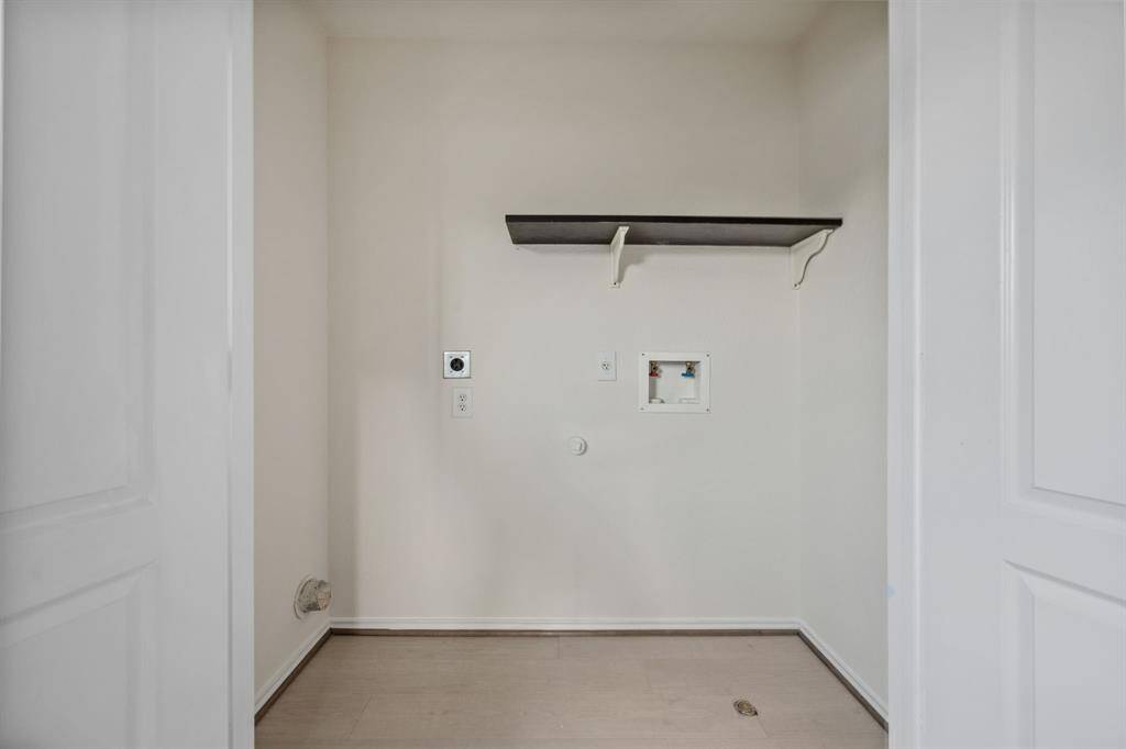 Upstairs laundry room with storage space and tile flooring.
