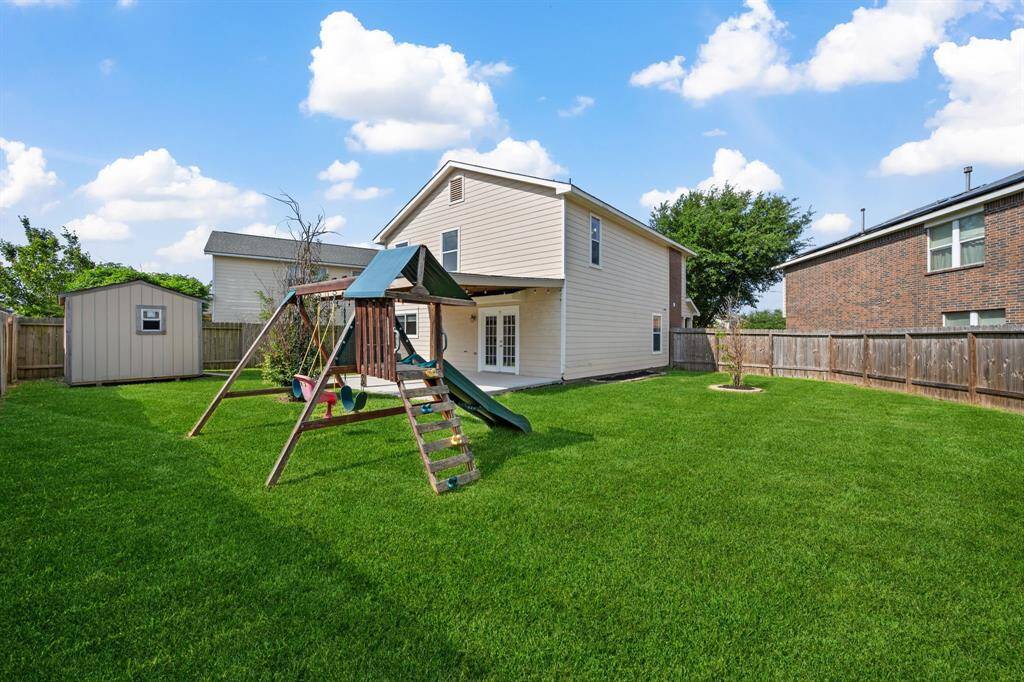 Another view of the large backyard with play space and open sky.