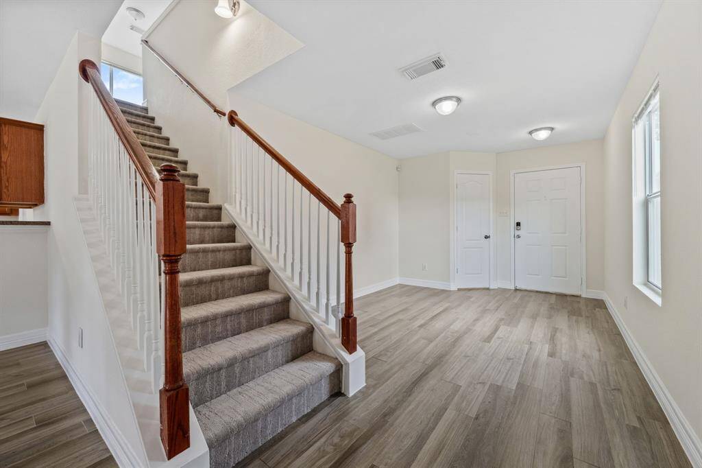 Open staircase with wood railing leading to upstairs bedrooms.