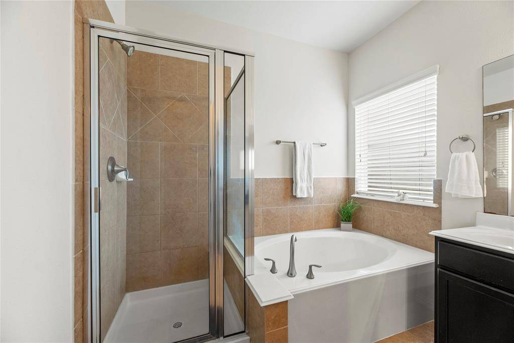 Another view of  bathroom featuring a modern design with a glass-enclosed shower and a separate bathtub.