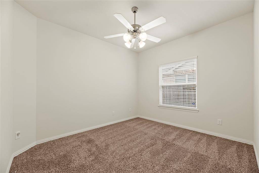 2nd bedroom features neutral walls, plush carpet, a ceiling fan.