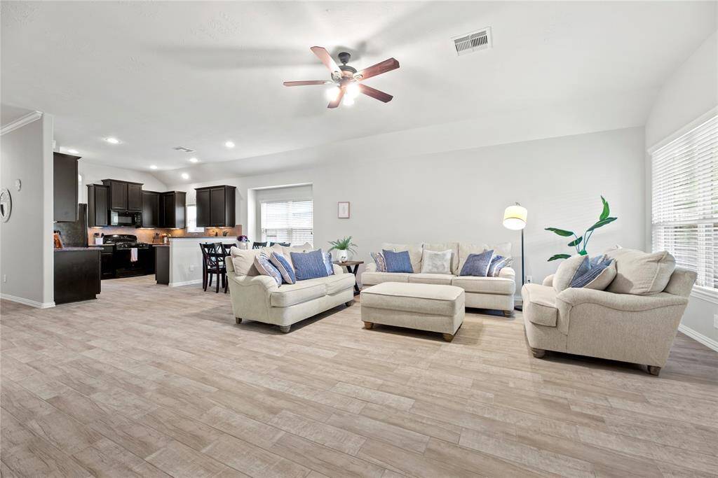 Open-concept living area with light wood flooring and ample natural light.