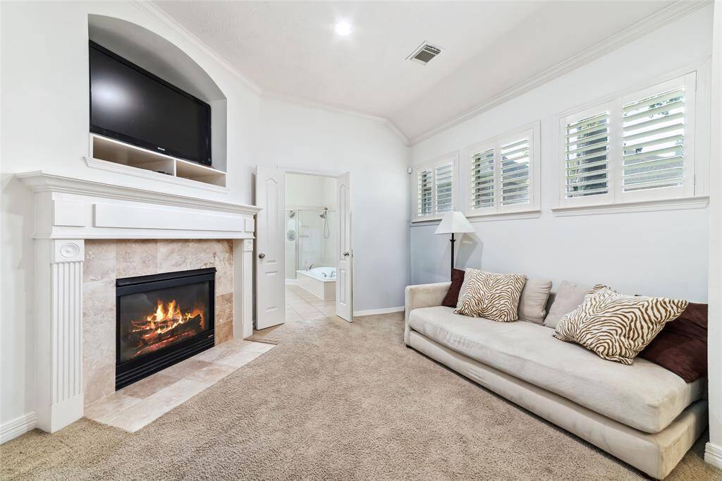 The primary bedroom offers a sitting area with a cozy remote start gas fireplace...an ideal space for relaxing, reading or catching up on your streaming!