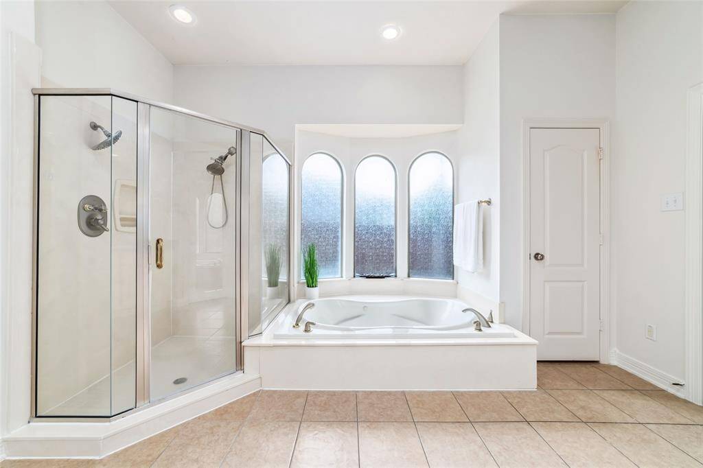 The star of this spa-like bathroom is the luxurious, deep soaking tub and oversized separate shower...with a wall of beautiful, arched windows to allow the diffused light to pour in.