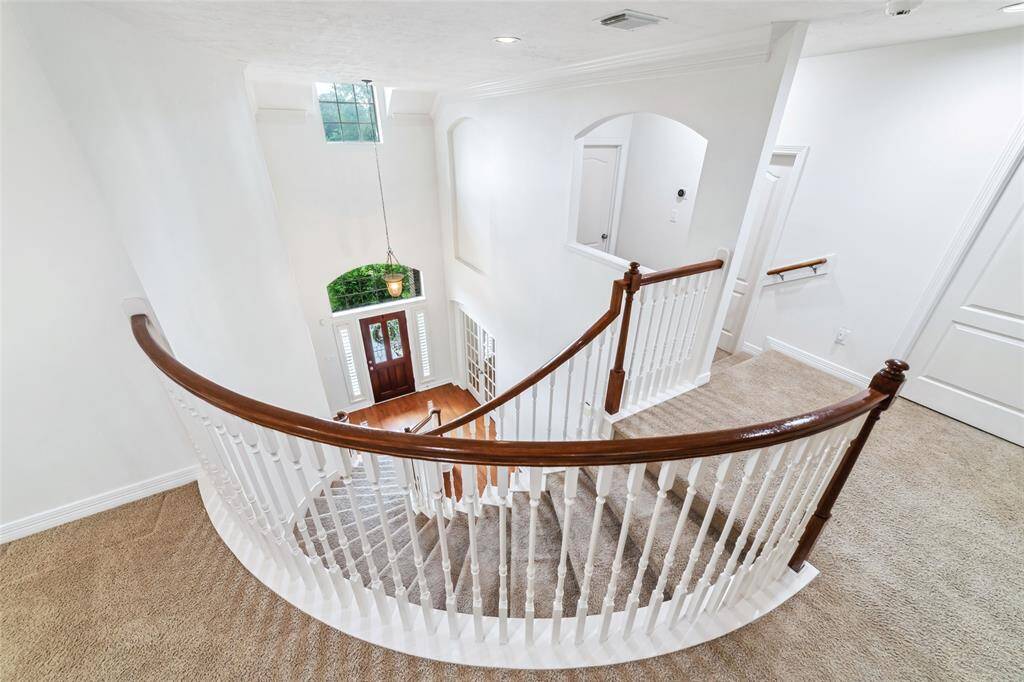 Enjoy a captivating view of the first floor from the grand staircase landing-a stunning architectural focal point.