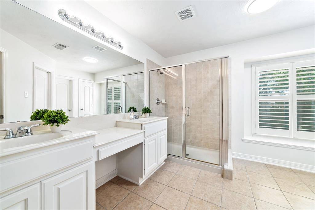 The spacious en-suite bathroom features dual vanities, oversized shower, a large walk-in closet, separate linen closet and tons of natural light.