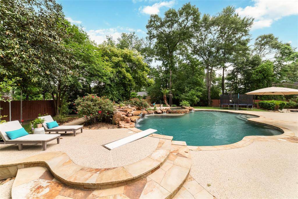 This resort-style backyard featues a sun deck area, perfect for loungers, right near the recently replaced recessed diving board.