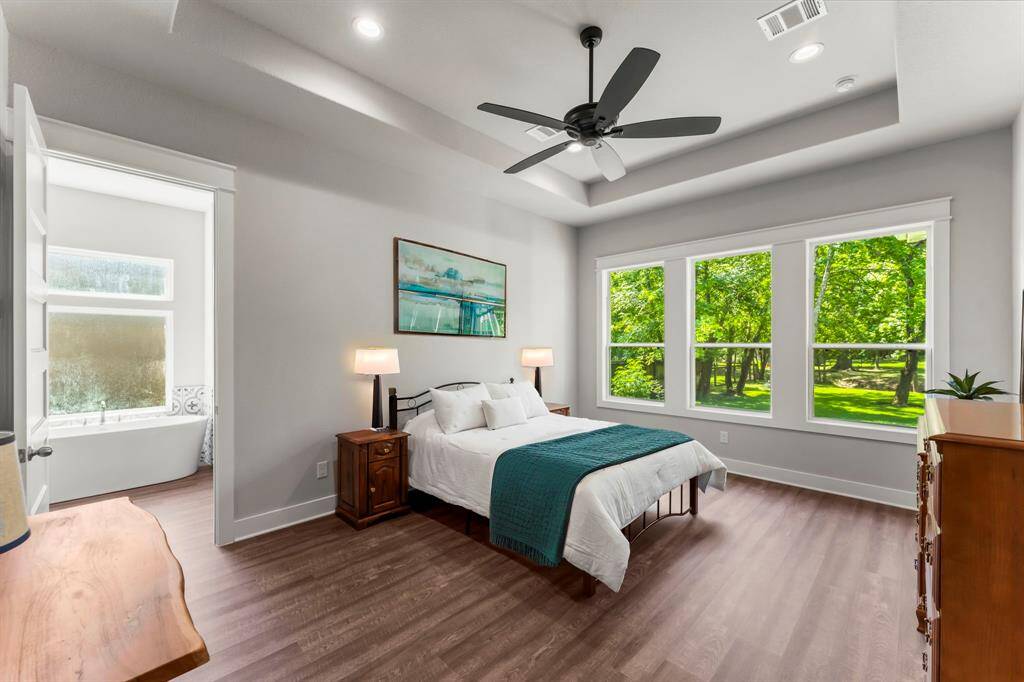 This Primary Bedroom offers the perfect retreat with amazing views of the lush backyard.
