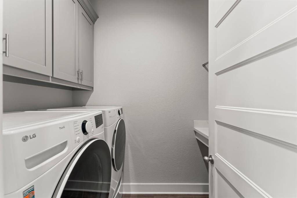 Laundry room offers extra storage and folding shelf.