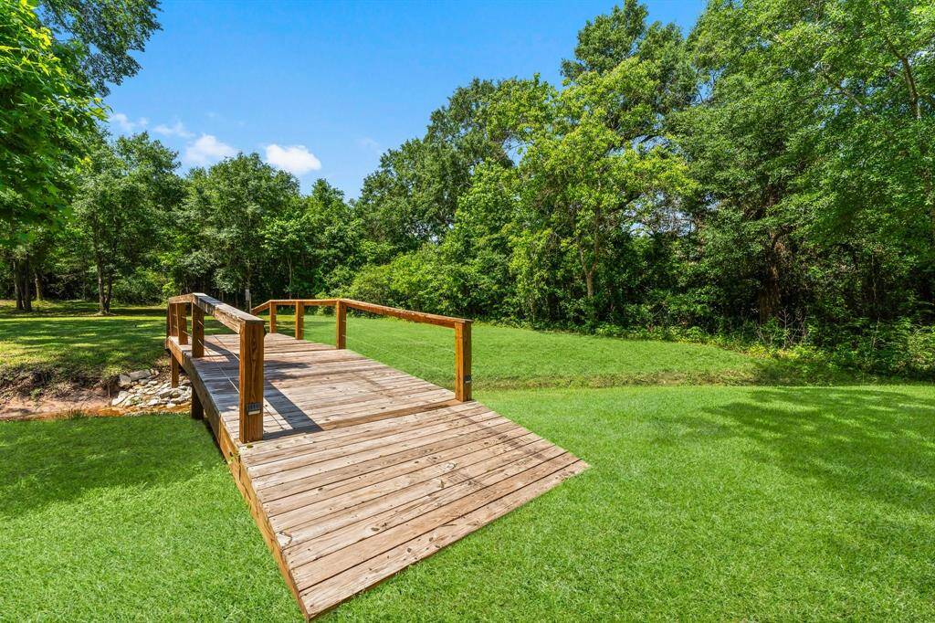 Custom-built bridge adds a unique and charming touch to the park-like setting.