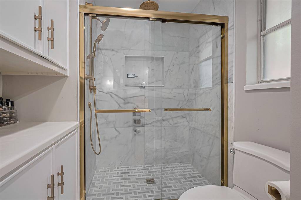 New beautiful walk in shower with 3 moen shower heads and marble surround.