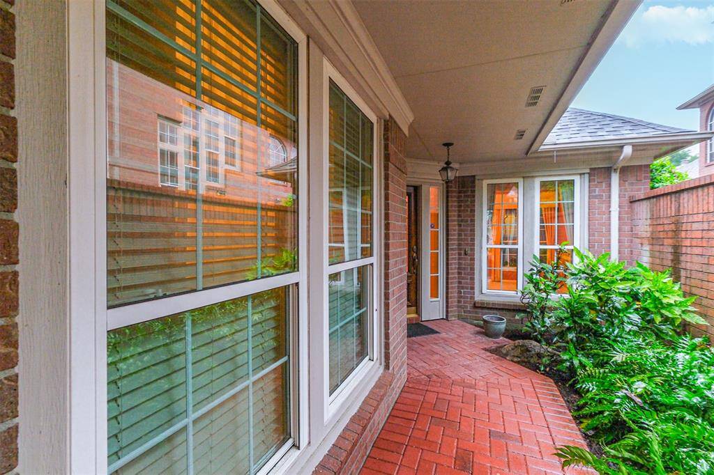 Beautiful foliage outlines the walkway to the front door.