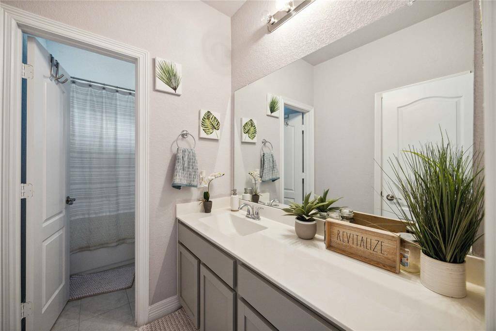 Bright and modern bathroom featuring a wide vanity with dual sinks, ample counter space.