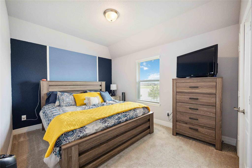 This cozy secondary bedroom features an accented wall feature, giving it a modern feel, with plenty of natural light.