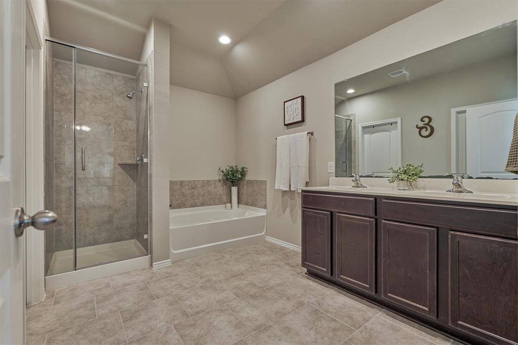 The en-suite primary bathroom features a soaking tub and a separate shower.