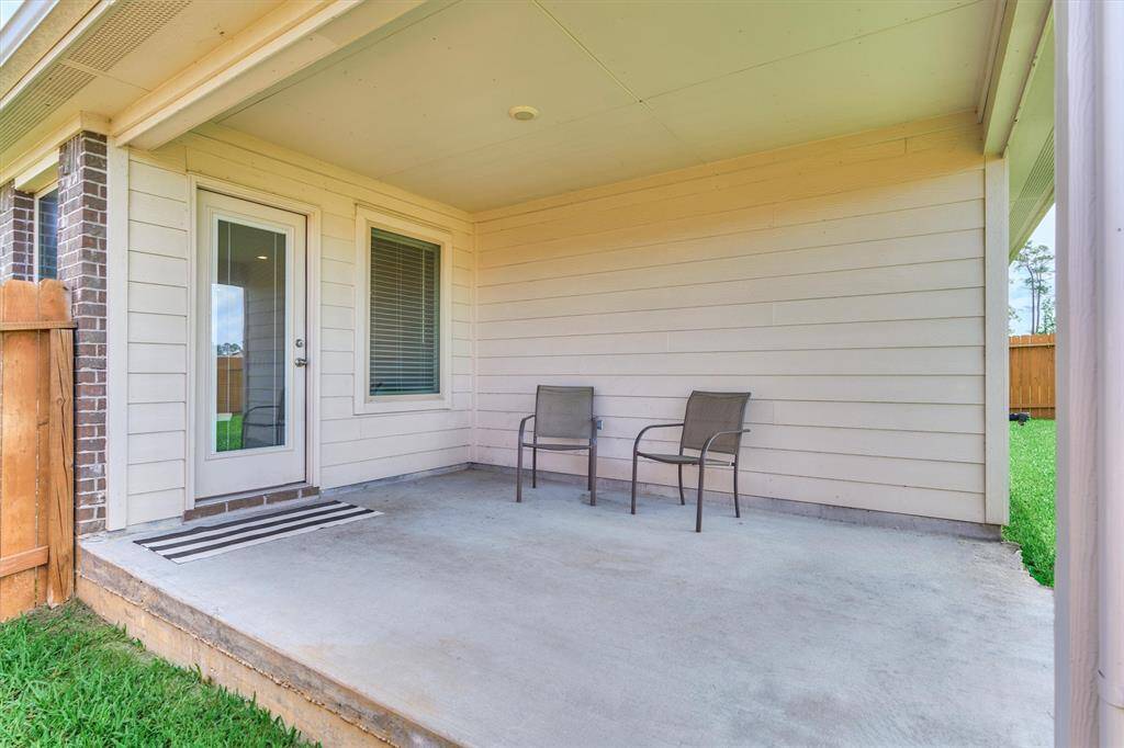 The covered back porch has plenty of room for your barbecuing equipment.