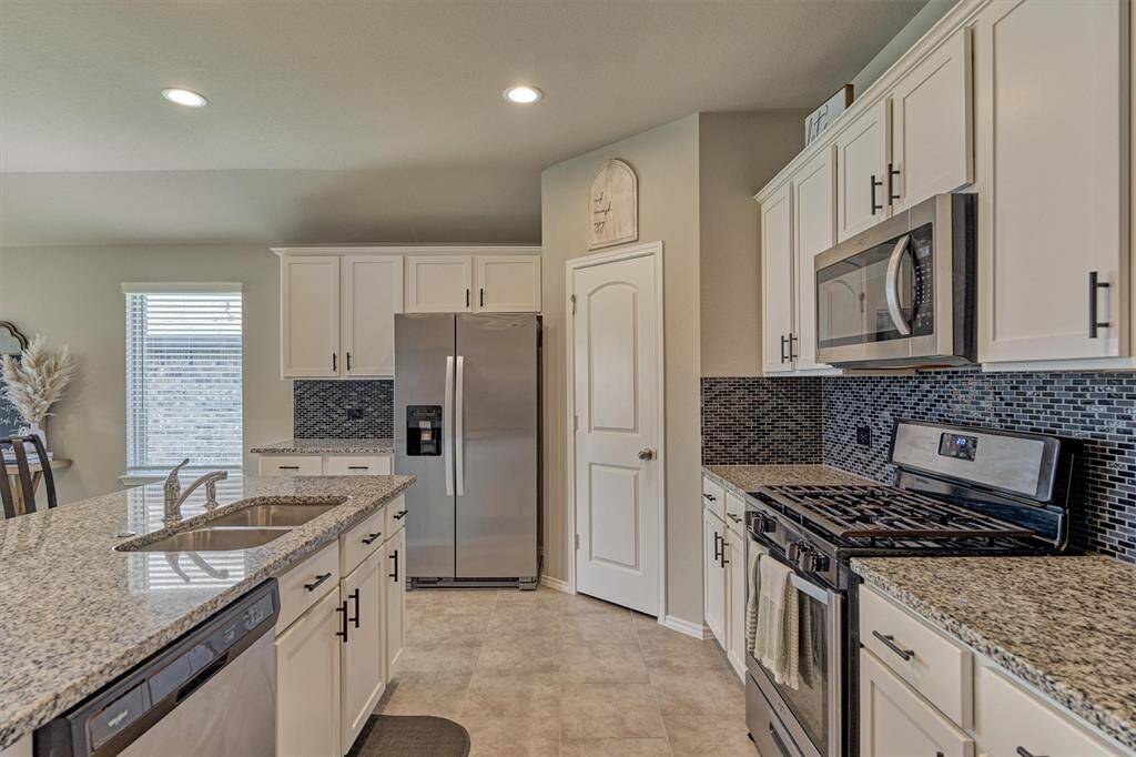 The kitchen features granite counter tops and stainless steel appliances.  The refrigerator is negotiable.  The walk-in pantry is to the right of the refrigerator.