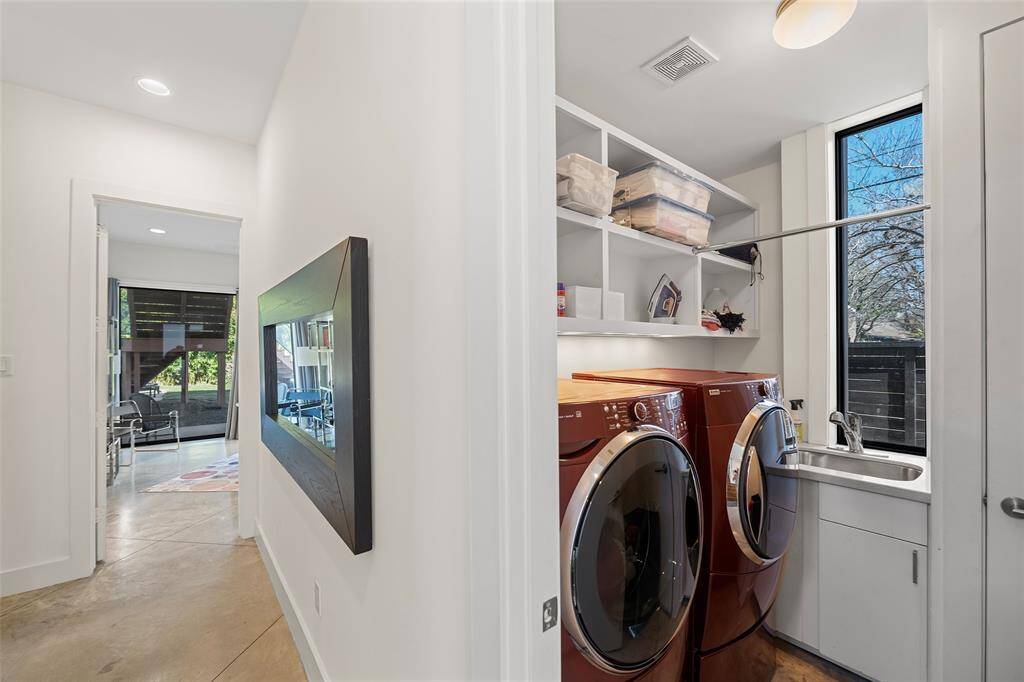 Laundry area with a sink and shelving located on the first floor.