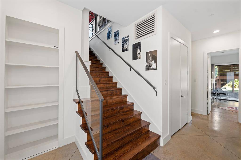 Stylish wooden staircase with a sleek handrail that invites you to the second floor.