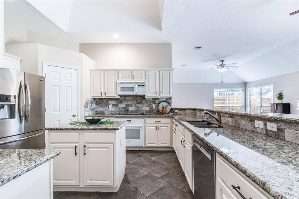 Central kitchen with granite counter tops. Skylight provides lots of light.