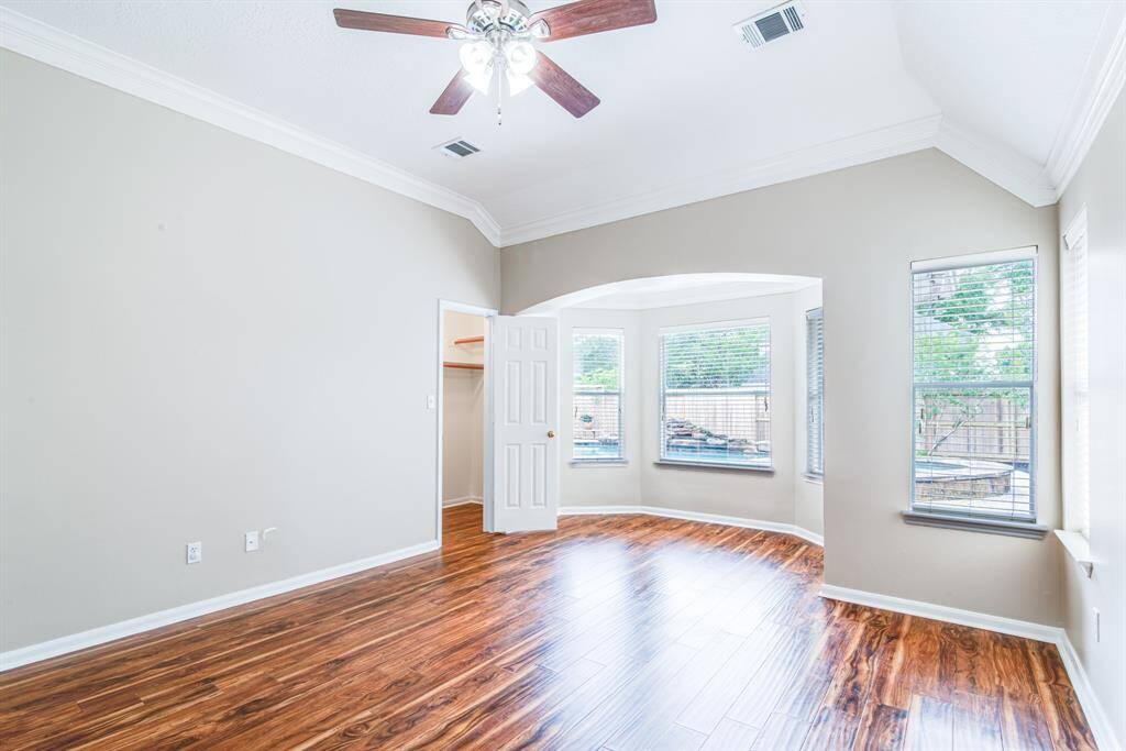 Primary bedroom with views of the pool.  Large room with sitting alcove.  Laminated floors.