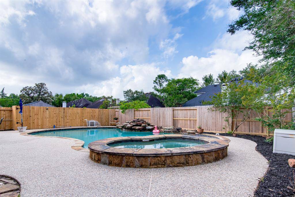 Spa, pool and rock waterfall.  Fences backyard.