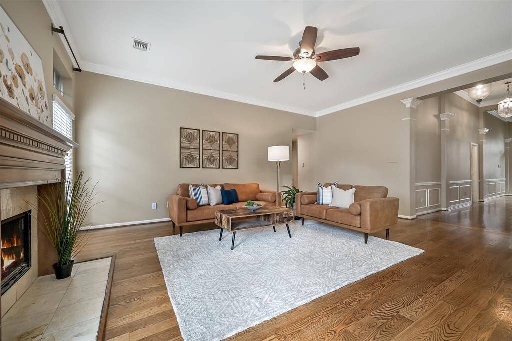 Continue straight ahead from the foyer to this warm and welcoming family room with freshly revarnished rich wood flooring, a cozy gas fireplace, crown molding, and a soaring ceiling—perfectly positioned just off the grand entry hall and open to the kitchen.