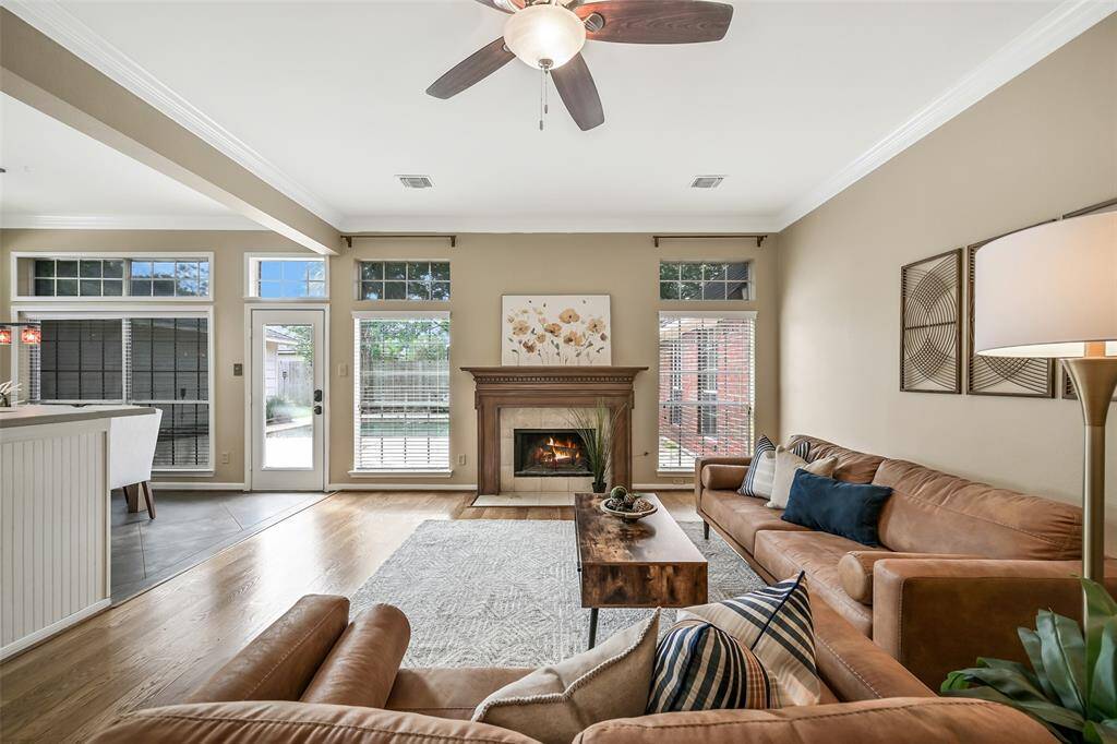The bright and airy family room is anchored by a gas fireplace flanked by a pair of windows overlooking the backyard oasis, plus direct patio access through a full panel glass door —perfect for indoor-outdoor entertaining.