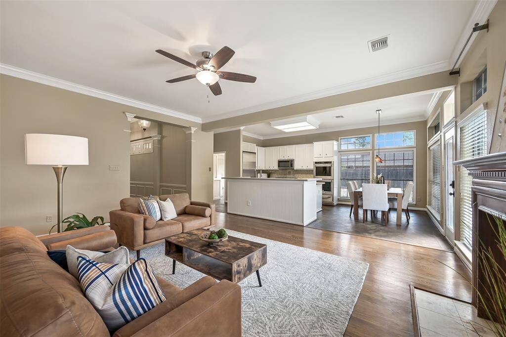 This open-concept layout connects the family room, kitchen, and breakfast nook, creating a seamless flow for daily living and entertaining—highlighted by natural light, crown molding, and a fireplace focal point.