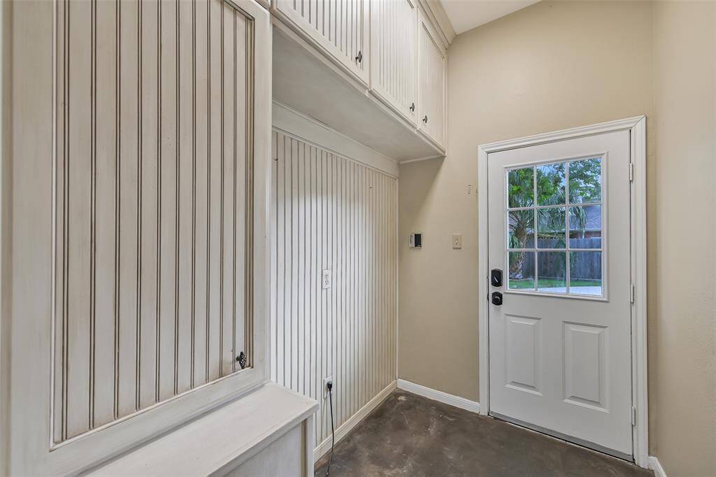 This charming mudroom—with built-in cabinetry and exterior access—was formerly the utility room and can easily be converted back by flipping the washer/dryer hookups around (they are currently facing the opposite side of this wall).