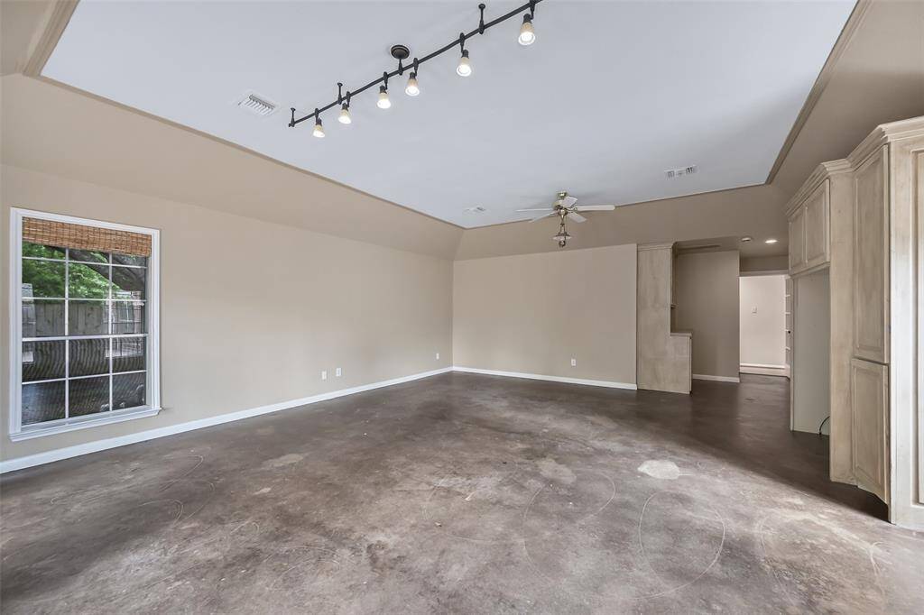Gather in this secluded gameroom with durable concrete flooring, a built-in entertainment center and bar area, and French door access to the backyard pool area—a great setup for a play room, pool house entertaining, or a private media retreat.