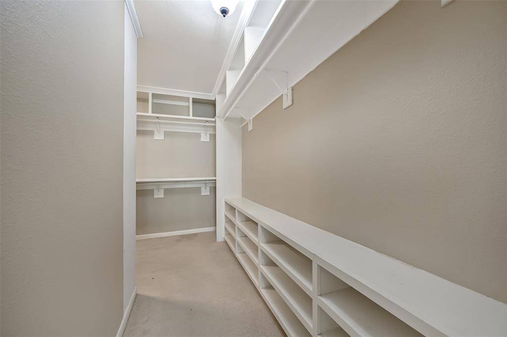 Expansive walk-in primary closet offers abundant built-in shelving, shoe storage, double hanging rods, and even includes a secure firearm safe—providing both function and peace of mind.