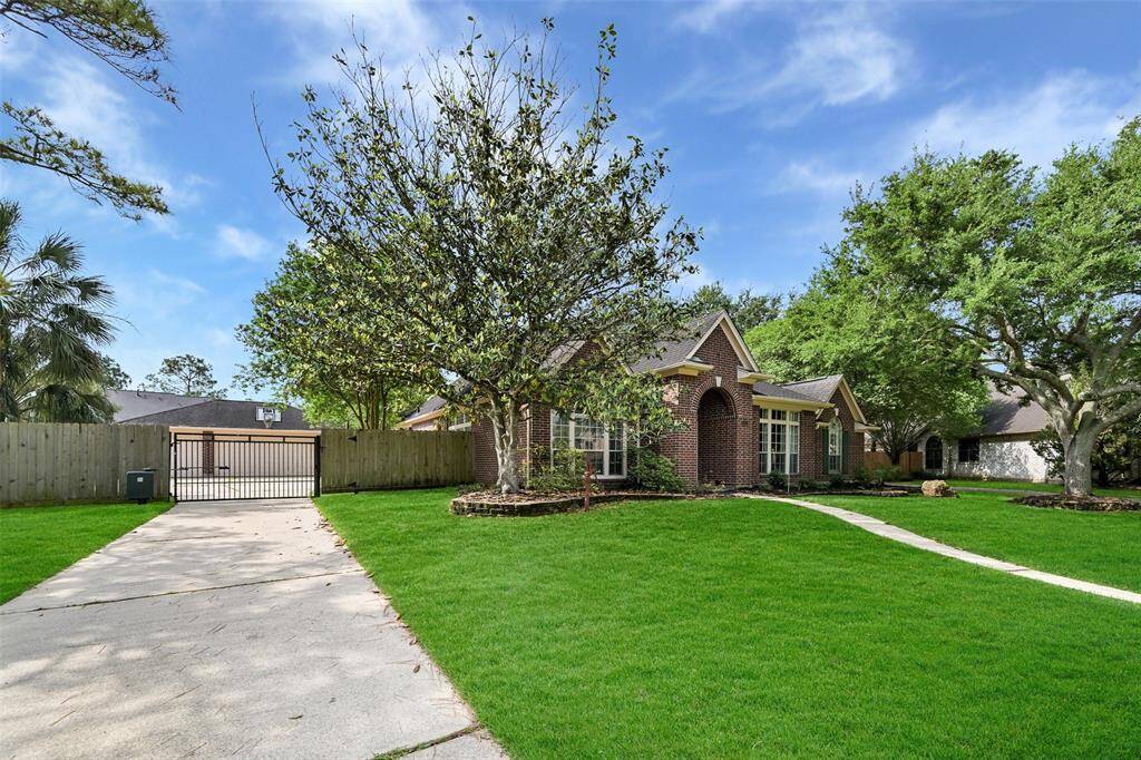 Extended driveway leads to a gated motor court and detached 3-car garage with a large parking pad, offering added privacy and secure parking—an ideal setup for families or entertaining guests.